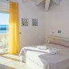Camera da letto luminosa con vista mare e balcone.