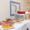 Buffet con salumi, formaggi e pane su una tovaglia bianca.