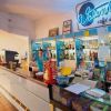 Bancone di un bar con prodotti esposti e una persona dietro il bancone.