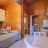 Camera in legno con due letti singoli, cucina e bagno.