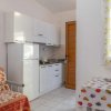 Cucina compatta con frigo e tavolo colorato.