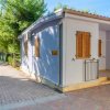 Casa blu con persiane marroni e vialetto di mattoni.