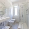 Bagno luminoso con doccia e finestra.