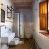Bagno con doccia, lavabo, wc e finestra in legno.