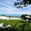 Piscina con lettini e ombrelloni, vista sull'oceano.