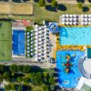 Vista dall'alto di una piscina con ombrelloni e giochi per bambini.