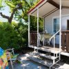 Casa mobile con veranda, sedie e tavolo.