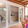 Terrazza con tavolo apparecchiato, cucina visibile.