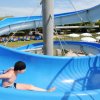 Persona su uno scivolo acquatico blu a spirale in un parco.