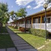 Viale alberato con case mobili e giardini curati.