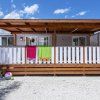Casetta in legno con teli colorati e palla.