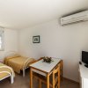 Camera con due letti singoli, tavolo, TV e condizionatore.