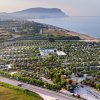Campeggio vicino al mare con piscina e alberi.