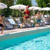 Ragazzi tuffano in piscina da bordo vasca.