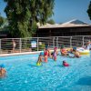 Bambini e adulti giocano in piscina.