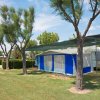 Caravan bianco e blu sotto alberi e tenda.