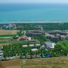 Veduta aerea di un'area costiera con campi e edifici.