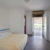 Camera da letto con letto matrimoniale, armadio e accesso alla terrazza.