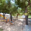 Un'area giochi all'aperto con altalene, scivoli e alberi ombrosi.