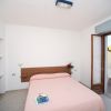 Camera da letto semplice con letto matrimoniale e porta che dà su un balcone.