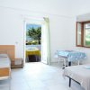 Camera luminosa con due letti singoli, una porta-finestra aperta su un balcone con vista sul mare.