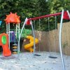 Parco giochi con altalene e scivoli colorati.