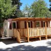 Bungalow con veranda in legno tra gli alberi.