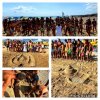 Persone in spiaggia attorno a sculture di sabbia.