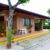 Una casa in mattoni con veranda, tavolo bianco e piante in vaso.