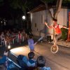 Spettacolo serale con artista su monociclo davanti a un pubblico di bambini.