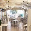 Ristorante con tettoia bianca, tavoli e sedie.