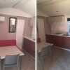 Interno di una cucina e area pranzo con mobili moderni, tavolo e sedie.