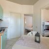 Interno di una cucina con tavolo, stoviglie, e porte verso le camere da letto.