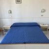 Letto matrimoniale con copriletto blu.