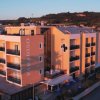 Edificio residenziale arancione con balconi, a fianco di altre strutture.