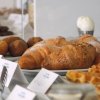 Tavolo della colazione con croissant, panini e waffle.