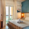 Camera con letto, tende bianche, vista mare.