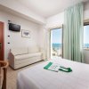 Camera con letto, divano, TV e vista mare.