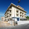 Edificio bianco con balconi su una strada.