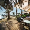 Terrazza con tavoli e ombrelloni vicino alla spiaggia.