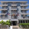 Facciata di un hotel blu con balconi bianchi.
