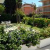 Un giardino con fiori colorati e tavoli in plastica.