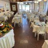 Sala da pranzo con tavoli apparecchiati e buffet di frutta sulla sinistra.