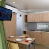 Cucina moderna con tavolo apparecchiato, TV a schermo piatto e frigorifero.