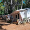 Bungalow bianchi tra gli alberi in un campeggio.