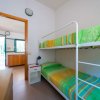 Cameretta con letto a castello e lenzuola verdi.