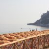 Spiaggia con ombrelloni colorati, scogliera sullo sfondo.