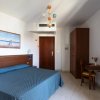 Stanza d'hotel con letto matrimoniale e arredi in legno.