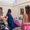 Salone di parrucchiere con stylist che taglia i capelli a un cliente.