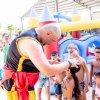 Animatore intrattiene bambini davanti a un gonfiabile.